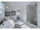 Bright bathroom with freestanding tub, glass enclosed shower, marble flooring, and black fixtures at 6977 Copper Sky Cir, Castle Pines, CO 80108