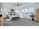 Bright bedroom features a ceiling fan, multiple windows, neutral walls, carpeting, and simple furnishings at 6977 Copper Sky Cir, Castle Pines, CO 80108