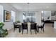 Dining room with modern lighting, sleek chairs, wooden table, and bright windows overlooking backyard at 6977 Copper Sky Cir, Castle Pines, CO 80108