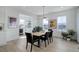 Dining area featuring a modern chandelier, wooden table, black chairs, and large windows at 6977 Copper Sky Cir, Castle Pines, CO 80108