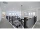 Open hallway with a dark railing overlooking the lower floor, bright lighting, and neutral carpeting at 6977 Copper Sky Cir, Castle Pines, CO 80108