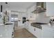Modern kitchen featuring white cabinets, stainless steel appliances, and a large island with quartz countertops at 6977 Copper Sky Cir, Castle Pines, CO 80108