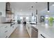 Bright, open kitchen showcasing a large island, stainless steel appliances, and a dining area in the background at 6977 Copper Sky Cir, Castle Pines, CO 80108