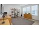 Bright living room features natural light, wood floors, a modern bookshelf and cabinet, and an area rug at 6977 Copper Sky Cir, Castle Pines, CO 80108