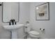 Powder room featuring a pedestal sink, sleek black plumbing fixtures, and modern decor at 6977 Copper Sky Cir, Castle Pines, CO 80108