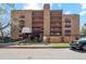 A brick apartment building featuring small balconies, a covered entryway, and well-maintained landscaping at 252 N Pennsylvania St # 102, Denver, CO 80203