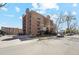 Apartment building exterior showing off brick architecture, small balconies, street-side parking, and mature shade trees at 252 N Pennsylvania St # 102, Denver, CO 80203