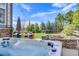 Relax in this backyard oasis, featuring a hot tub, fire pit, and outdoor dining area at 703 Tiger Lily Way, Highlands Ranch, CO 80126