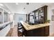 Modern bar area with sleek countertop, cabinets, and seating for entertaining guests at 703 Tiger Lily Way, Highlands Ranch, CO 80126