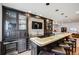 Stylish bar area with cabinetry, stone backsplash, and seating for relaxation and entertainment at 703 Tiger Lily Way, Highlands Ranch, CO 80126