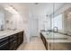 Bathroom with double sinks, dark wood cabinets, tile floors, and a separate water closet at 703 Tiger Lily Way, Highlands Ranch, CO 80126