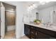 Bathroom features double sinks, dark cabinets, and a separate shower and toilet area at 703 Tiger Lily Way, Highlands Ranch, CO 80126