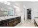 Beautiful bathroom featuring dual sinks, a large mirror, and a door to a spacious walk-in closet at 703 Tiger Lily Way, Highlands Ranch, CO 80126