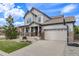 Inviting two-story home showcasing a covered front porch and an attached two-car garage at 703 Tiger Lily Way, Highlands Ranch, CO 80126