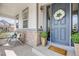 Charming front porch with stone details, a welcoming blue door, and comfortable seating at 703 Tiger Lily Way, Highlands Ranch, CO 80126
