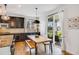 Kitchen featuring dark cabinets, granite countertops, pendant lighting, and a wooden table that leads to an outdoor patio at 703 Tiger Lily Way, Highlands Ranch, CO 80126