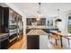 Bright kitchen with dark wood cabinets, stainless steel appliances, a granite island and wooden table at 703 Tiger Lily Way, Highlands Ranch, CO 80126