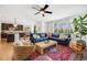 Open-concept living room featuring a comfortable blue sectional sofa, a ceiling fan, and an open view of the kitchen at 703 Tiger Lily Way, Highlands Ranch, CO 80126