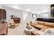 Bright living room with comfortable brown leather sofa, piano, and convenient bar area at 703 Tiger Lily Way, Highlands Ranch, CO 80126