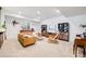 Open living room with a beige sofa, bookcases, a tv, and a piano at 703 Tiger Lily Way, Highlands Ranch, CO 80126
