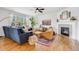 Comfortable living room area features a fireplace, blue sofa, wood floors and large windows at 703 Tiger Lily Way, Highlands Ranch, CO 80126