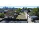 A vacant lot is surrounded by a wooden fence and lush trees, offering a serene setting with a city skyline backdrop at 1735 W 37Th, Denver, CO 80211
