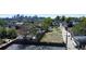 An aerial shot shows a vacant lot surrounded by mature trees, with the city skyline visible in the background at 1735 W 37Th, Denver, CO 80211