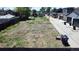 An aerial view of a vacant lot, bordered by a wooden fence and adjacent to a residential street with trash receptacles at 1735 W 37Th, Denver, CO 80211