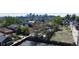 An aerial view captures a vacant lot surrounded by mature trees and neighboring homes, with the city skyline in view at 1735 W 37Th, Denver, CO 80211