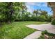 Lush green backyard with mature trees and a patio area, ideal for outdoor enjoyment at 4906 E Bates Ave, Denver, CO 80222