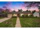 Charming single-story home at twilight, featuring a well-manicured lawn and a welcoming red front door at 4906 E Bates Ave, Denver, CO 80222