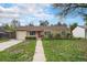 Charming single-story home featuring a well-manicured lawn and a welcoming red front door at 4906 E Bates Ave, Denver, CO 80222