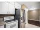 Kitchen featuring stainless steel refrigerator and stove and white cabinets at 4906 E Bates Ave, Denver, CO 80222