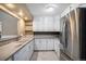 Bright kitchen features white cabinets, stainless steel refrigerator and tile flooring at 4906 E Bates Ave, Denver, CO 80222