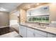 Bright kitchen featuring white cabinets, stainless steel refrigerator and eat-in countertop at 4906 E Bates Ave, Denver, CO 80222