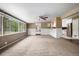 Bright living room with natural light, neutral carpet, ceiling fan, and access to the kitchen at 4906 E Bates Ave, Denver, CO 80222