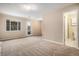 Large living room with neutral walls, carpet floors, large windows, and a door to the backyard at 4906 E Bates Ave, Denver, CO 80222