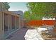 Backyard with a tree, picnic table, wood fence, stone patio, and enclosed back porch at 1920 Elmira St, Aurora, CO 80010
