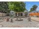 Backyard with fire pit surrounded by gravel, mature tree, and picnic benches for relaxation at 1920 Elmira St, Aurora, CO 80010