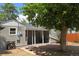 Backyard featuring a large tree, wood fence, covered patio, and well-maintained landscape at 1920 Elmira St, Aurora, CO 80010