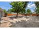 Large backyard with a shade tree, picnic benches, wood fence, and stone patio at 1920 Elmira St, Aurora, CO 80010