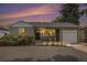 Charming single-story home with warm exterior lighting and a meticulously landscaped front yard at dusk at 1920 Elmira St, Aurora, CO 80010