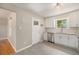 Bright kitchen features stainless steel appliances, gray tile floor, white cabinets, and backyard door at 1920 Elmira St, Aurora, CO 80010