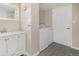 Bathroom includes laundry closet, modern sink and vanity, grey tile flooring, and light walls at 1920 Elmira St, Aurora, CO 80010
