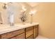 Bright bathroom featuring double sinks, decorative flower arrangement, and modern lighting fixtures over a tiled vanity at 3866 S Dallas Cir # 12202, Aurora, CO 80014