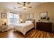 Serene bedroom with a queen-size bed, wood floors, and a window with natural light at 3866 S Dallas Cir # 12202, Aurora, CO 80014