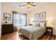 Well-lit bedroom with a ceiling fan, hardwood floors, a window, tasteful decor, and neutral wall paint at 3866 S Dallas Cir # 12202, Aurora, CO 80014