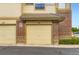 Garage doors with brick and tan siding at 3866 S Dallas Cir # 12202, Aurora, CO 80014