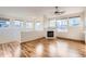 Cozy living room featuring light wood floors, a fireplace, lots of windows, and a ceiling fan at 3866 S Dallas Cir # 12202, Aurora, CO 80014