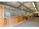 Barn with multiple stalls, wood paneling, and brick flooring at 5700 S University Blvd, Greenwood Village, CO 80121